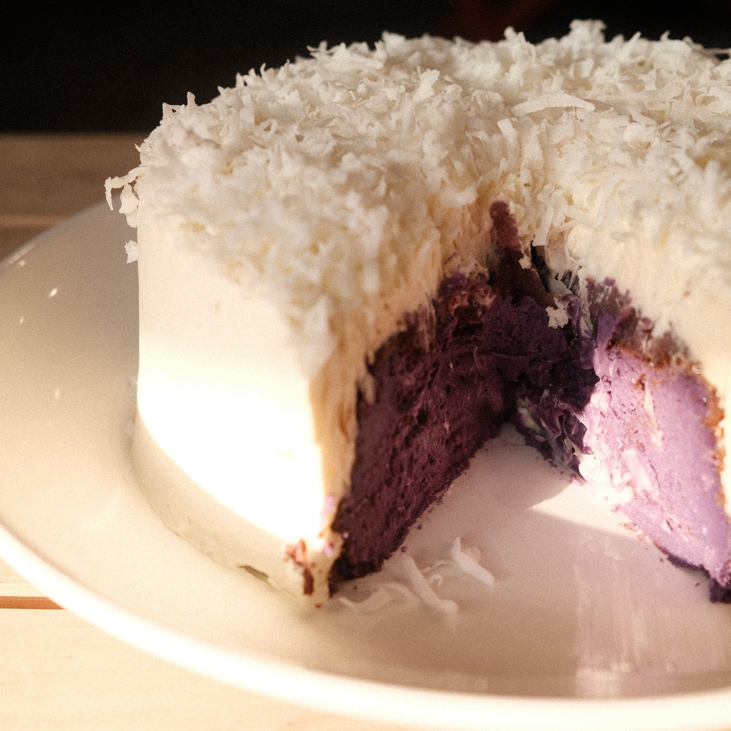 Ube basque cheesecake on a white plate with one slice missing. 
